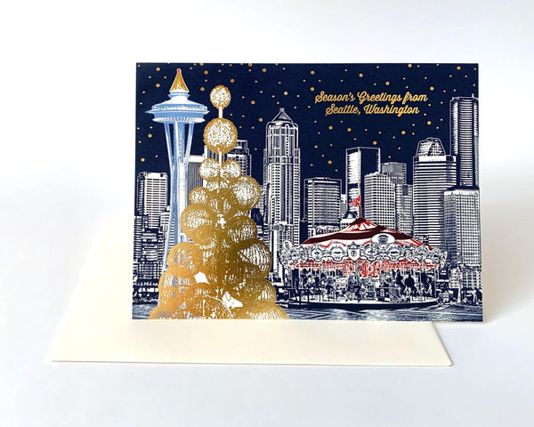 Seattle Holiday Card...the downtown lights, carousel, and the Space Needle. The two Space Needle trees, stars, and the &quot;Seasons Greetings&quot; message are made with a beautiful gold-bronze colored foil, providing a wonderful holiday light effect.